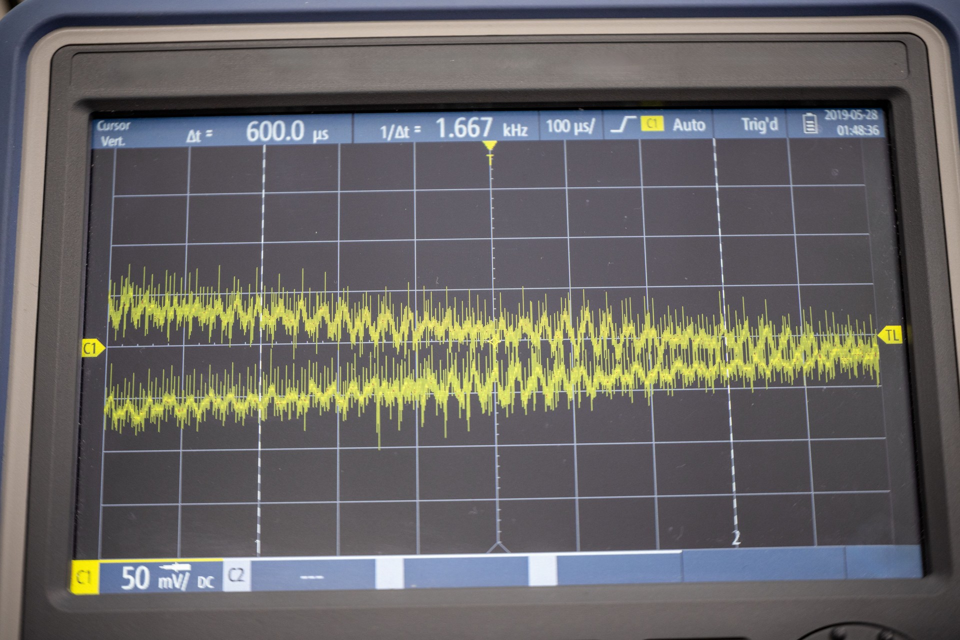 High-resolution close-up of an oscilloscope screen showing an electrical waveform at 1.667 kHz.